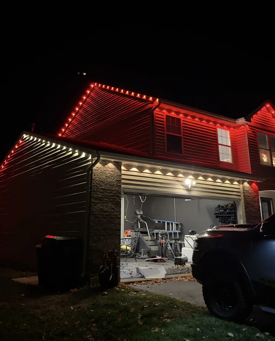 Warm red and white Christmas roofline lighting on a home in Wheeling, IL