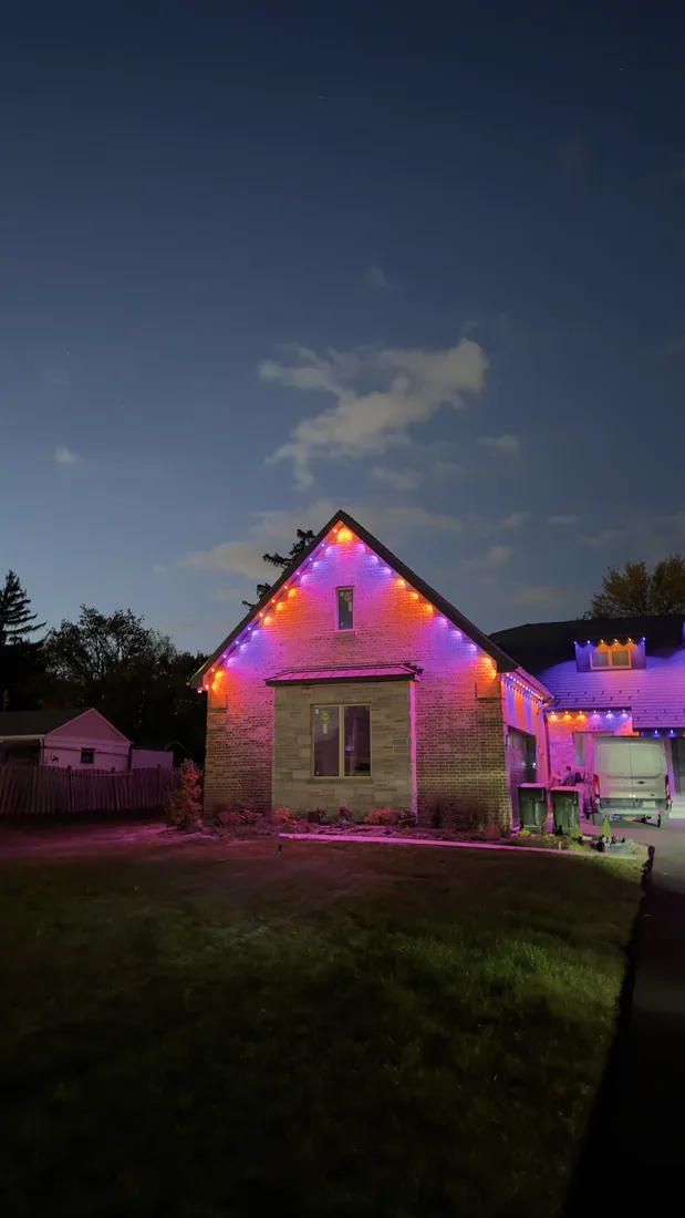 Color-changing permanent lighting on a brick home at dusk in Wheeling, IL — Perfect Touch