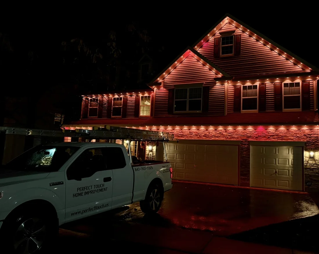 Warm white permanent roofline lighting on a home in the North Shore — Perfect Touch