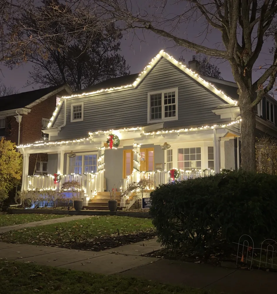 Warm white Christmas roofline lighting with wreaths on a craftsman home in the North Shore - Perfect Touch